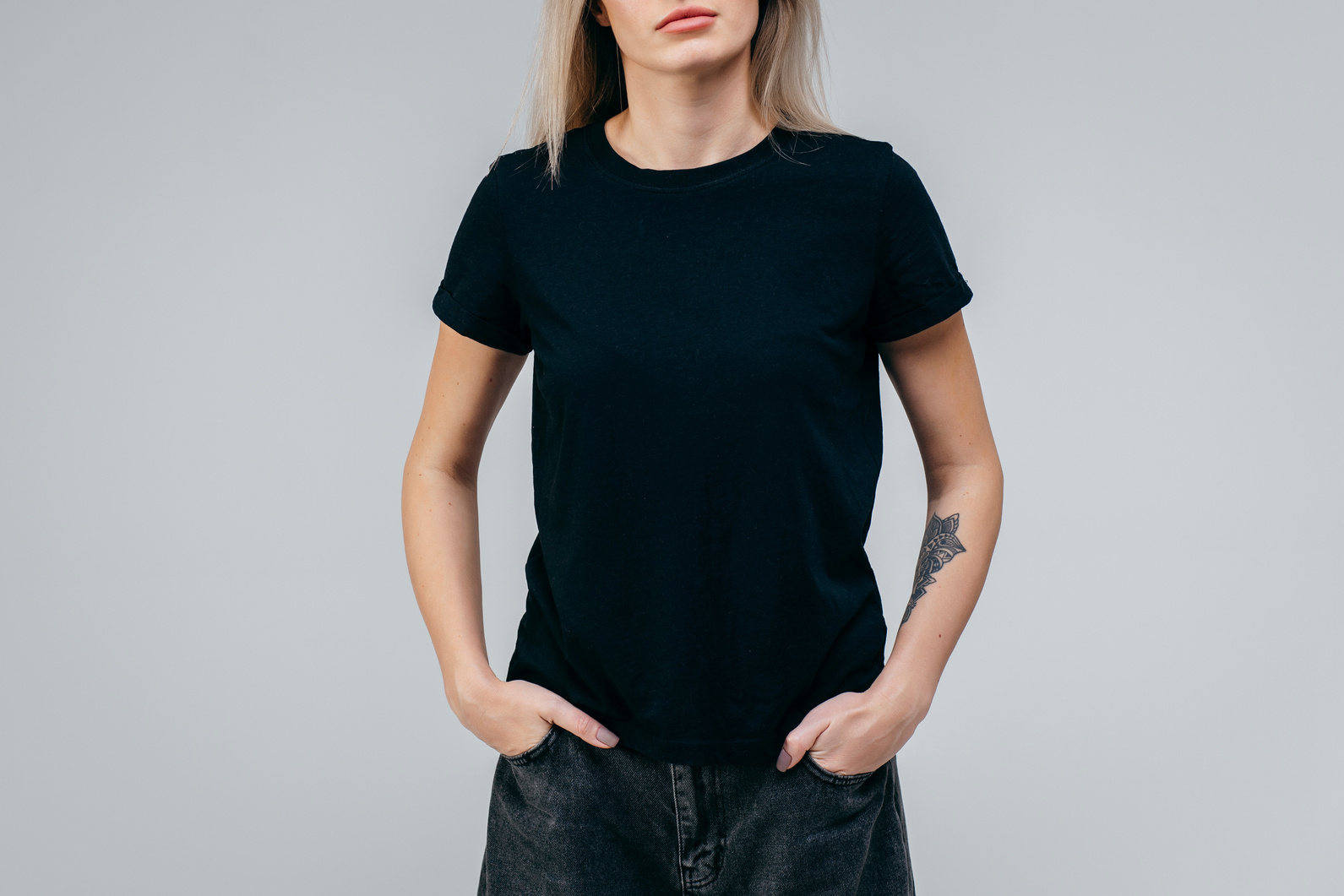Stylish blonde girl wearing black t-shirt posing in studio
